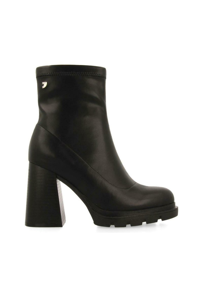 Botines negros con un tacón alto y grueso, material de cuero liso, punta redondeada y detalles de costura en el tobillo. Incluye acento de logo.