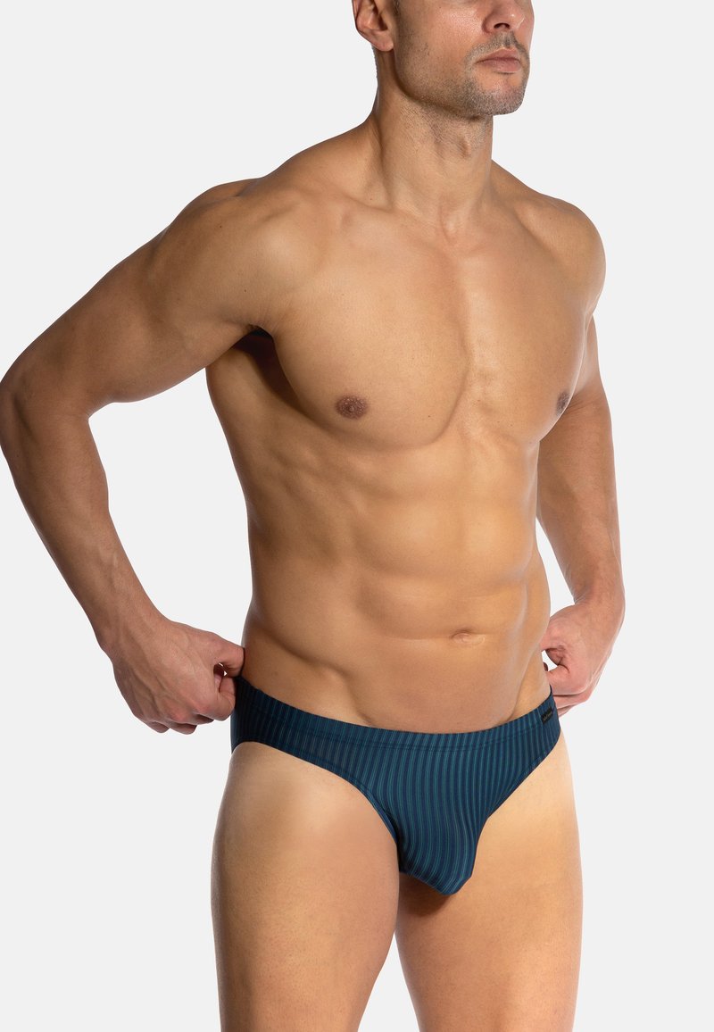 Marineblau gestreifter Badeanzug mit einem tief sitzenden Design, gefertigt aus glattem, dehnbarem Material. Verfügt über einen kontrastierenden Bund für zusätzlichen Detailreichtum.