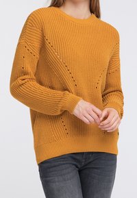 Sininen keltainen neulepusero, jossa on ribbikuvio, pyöreä pääntie ja koristeelliset silmukkakuviot hihoissa. Istuu hyvin hihansuissa ja helmoissa.