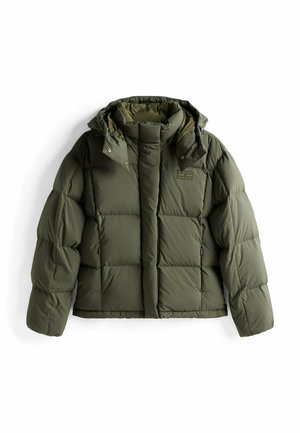 Veste matelassée en vert olive foncé, avec une silhouette carrée, une texture rembourrée, une capuche amovible et des poches latérales zippées.