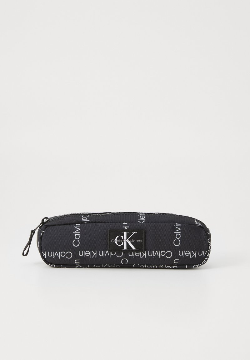 Astuccio nero con una texture liscia, caratterizzato da testo bianco "Calvin Klein Jeans" in diverse direzioni e una chiusura con zip.