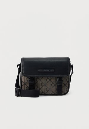 Sac bandoulière Calvin Klein noir et marron avec motif logo, fermeture à rabat, sangle réglable et boucles avant.