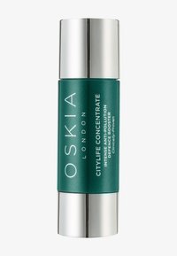 Bouteille cylindrique verte avec un capuchon argenté, étiquetée "OSKIA Citylife Concentrate." Le texte met en avant les propriétés anti-pollution et de défense intense.