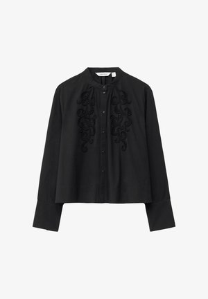 Schwarze Bluse mit langen Ärmeln, Stehkragen, Knopfleiste, breiten Manschetten und gesticktem Wirbelmuster auf der Vorderseite der Brust.
