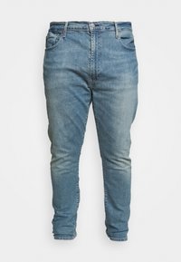 Light blue denim jeans with a slim fit, featuring a classic five-pocket design, button fastening, and slightly faded fabric texture.