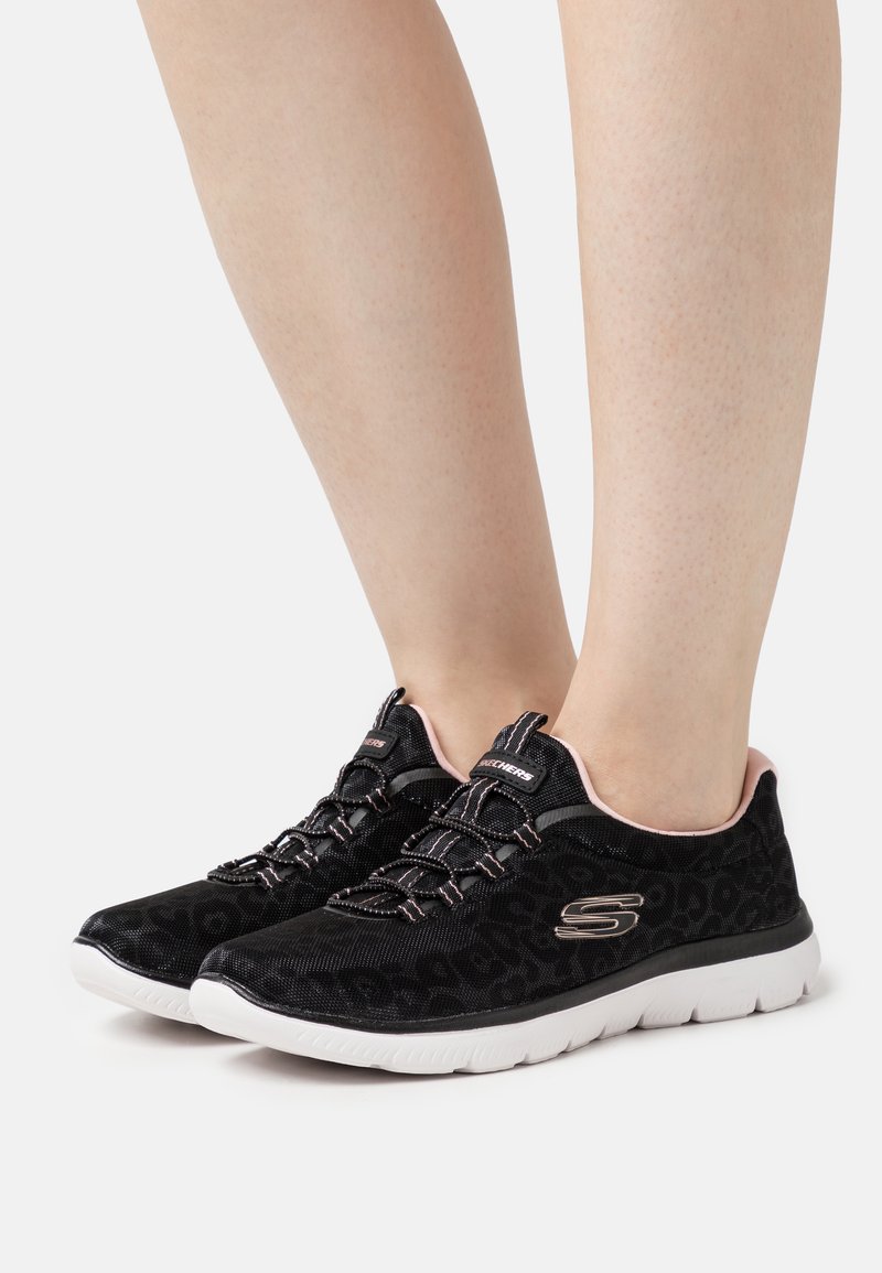 Black leopard print sneakers with elastic laces and a pink collar. White sole with textured tread for grip and comfort.