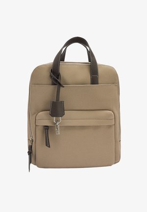 Beżowy plecak z tkaniny z ciemnobrązowymi skórzanymi uchwytami i zapięciem. Posiada przednią kieszeń z breloczkiem i kontrastowym szwem.