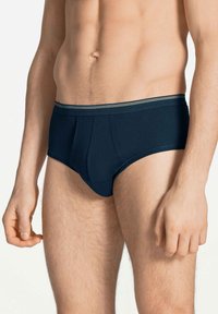 Donkerblauwe katoenen slips met een snug fit. Heeft een zachte, elastische tailleband verlevendigd met een dunne, contrasterende streep.