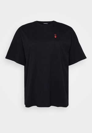 T-shirt nera in cotone con maniche corte, vestibilità ampia, scollatura rotonda, con un piccolo logo a forma di cuore rosso nell'area sinistra del petto.