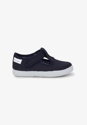 Scarpa Mary Jane in tela navy con strap in Velcro, suola in gomma bianca e fodera a quadretti. Presenta punta arrotondata e design flessibile.