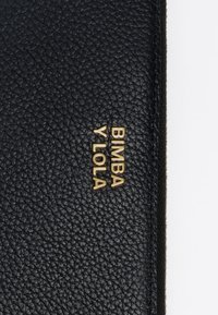 Čierna textúrovaná kožená peňaženka s zlatým logom "Bimba y Lola". Uzatváranie na zips s odolným šitím a elegantnými dizajnovými akcentmi.