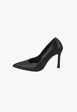 Schwarzer High Heel Schuh mit spitzem Zeh, strukturiertem Obermaterial, das mit kleinen Strasssteinen bedeckt ist, und einem Stiletto-Absatz. Offene Seiten für ein zusätzliches Design.
