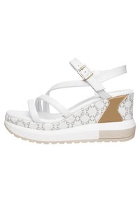 Sandali wedge bianchi con design a strisce, tacco decorato e accentuazione beige; presentano una cinturino alla caviglia regolabile e materiali testurizzati.