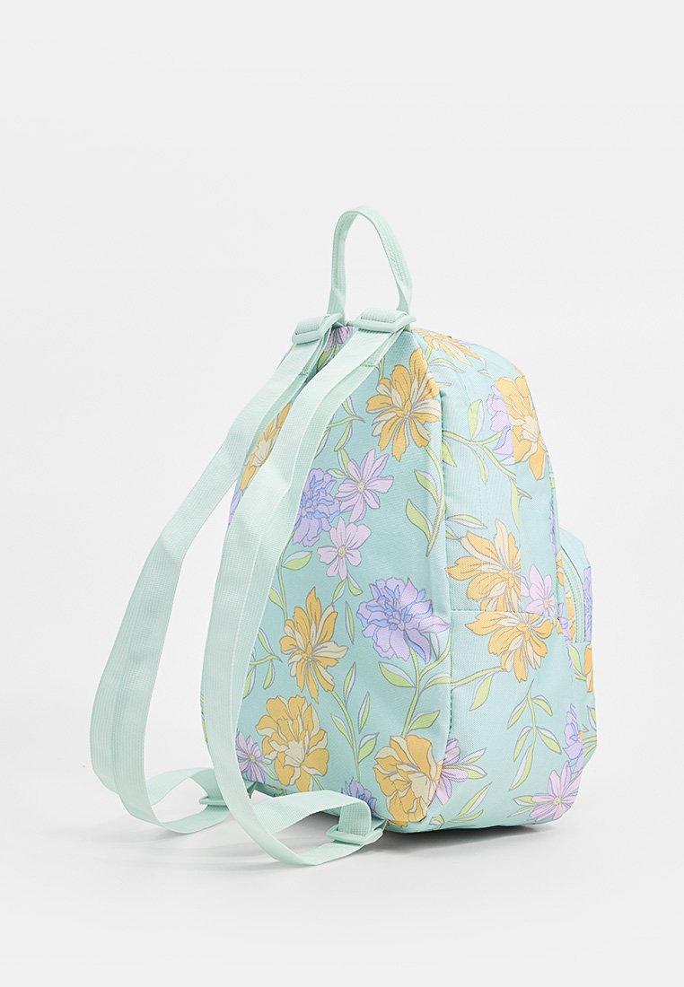 Zaino con motivo floreale su base verde menta, decorato con fiori gialli e viola. Tessuto morbido, forma arrotondata e spallacci regolabili.