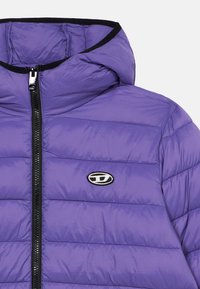 Μωβ μπουφάν με επένδυση, ψηλό γιακά, κλείσιμο με φερμουάρ και μαύρες λεπτομέρειες. Διαθέτει ραμμένο σχέδιο και κυκλικό λογότυπο στο στήθος.