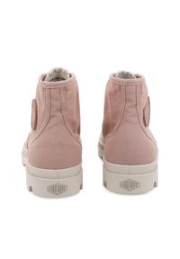 Ζευγάρι ανοιχτό ροζ καμβά παπουτσιών ψηλής κορυφής με λευκές καουτσούκ σόλες, σε θέα από πίσω, με το λογότυπο "Palladium" στη φτέρνα.