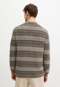 Gestreepte gebreide trui in bruin, blauw en beige. Heeft een ronde kraag, geribbelde manchetten en een textuur met horizontale lijnen.