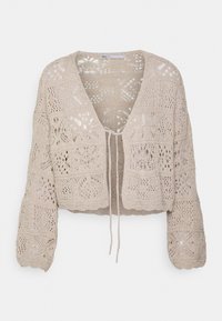 Cardigan de ganchillo beige con escote en V, diseño corto, mangas largas y patrones florales intrincados. Las cintas en la parte delantera añaden detalle.