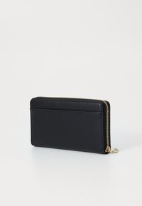 Portafoglio zip in pelle nera con una texture liscia, dotato di hardware della cerniera in tono oro e di uno slot per carte sul davanti.