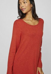 Maglione lavorato a maglia in una calda tonalità di rosso, con scollatura a U, maniche lunghe e finitura testurizzata per un maggiore calore e comfort.