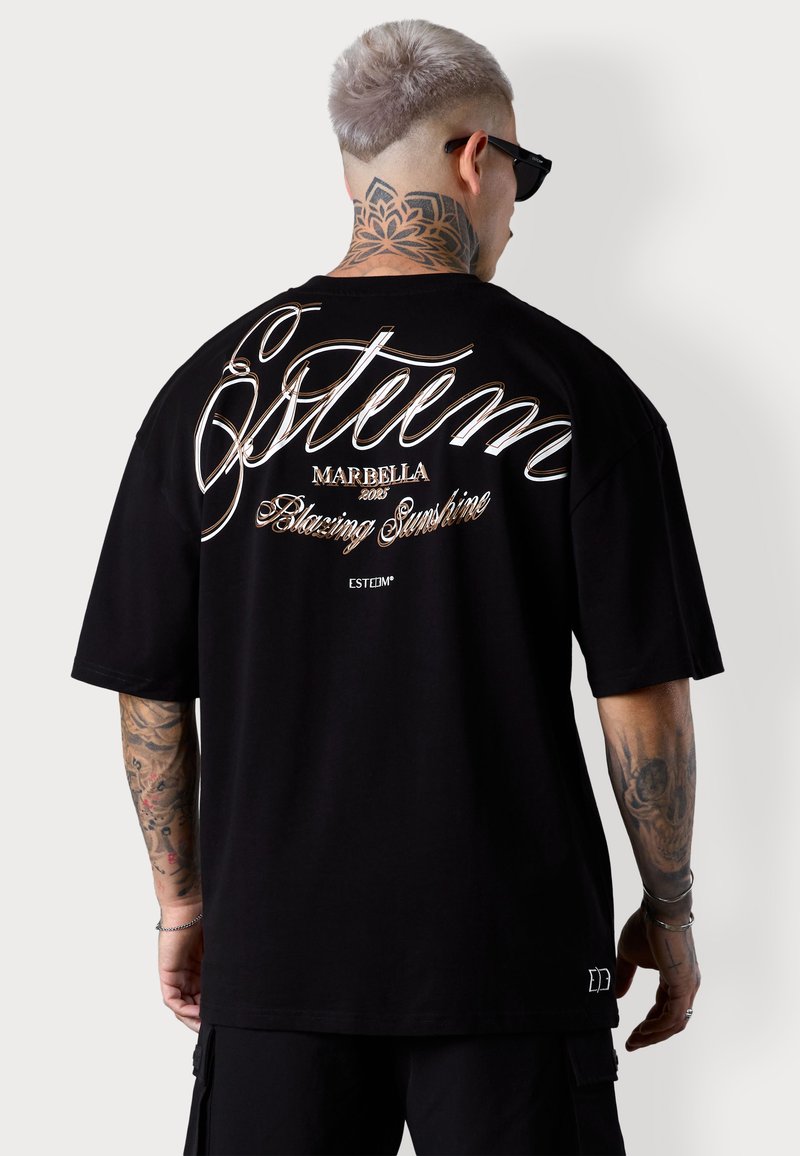 Schwarzes, übergroßes T-Shirt mit schriftartähnlichem Text auf dem Rücken, einschließlich Logos und Designdetails, aus weichem Stoff gefertigt.