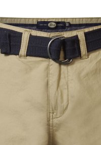 Beige broeken met een gladde textuur, voorzien van een donkerblauwe geweven riem met een zilverkleurige metalen gesp en een logo-label op de tailleband.