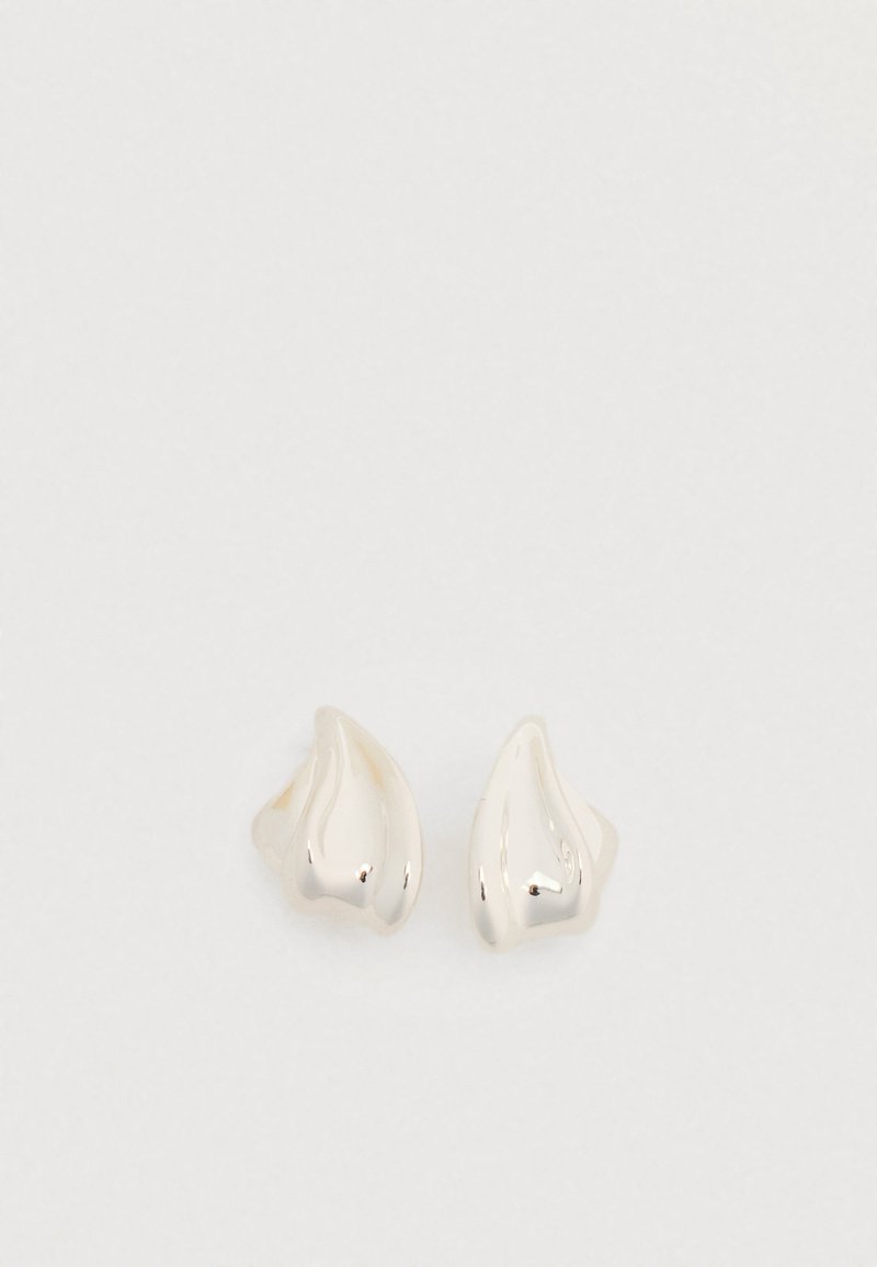 Boucles d'oreilles ton argent avec une forme organique lisse en goutte d'eau. Surface polie avec une courbure subtile et sans ornements visibles.