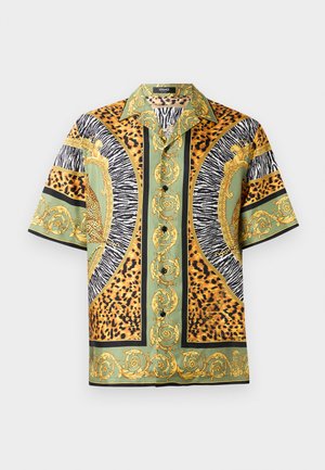 Camisa de manga corta con botón que presenta un patrón audaz con estampados de animales en tonos de verde, naranja, negro y acentos dorados. Textura de tejido suave.