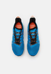 Scarpe da ginnastica blu con una parte superiore in mesh traspirante, dettagli arancioni, lacci neri e una suola testurizzata per una migliore aderenza. Presentano dettagli perforati.