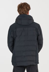 Sort puffertjakke med hætte, der har en quiltet tekstur og en længere ryg. Designet inkluderer elastiske manchetter og en glat finish.