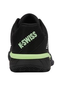 Zapatilla deportiva negra con parte superior de malla texturizada, acentos verdes y marca K-Swiss. Cuenta con una suela acolchada y un diseño de talón que proporciona soporte.