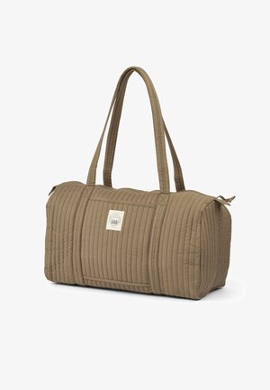 Quilted beige duffel bag with long handles, rectangular shape, side pocket, and a logo patch, featuring a textured, ribbed surface.