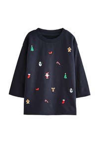 Chemise à manches longues bleu marine ornée de broderies festives colorées représentant des icônes de Noël, y compris des sapins, des chaussettes et le Père Noël.