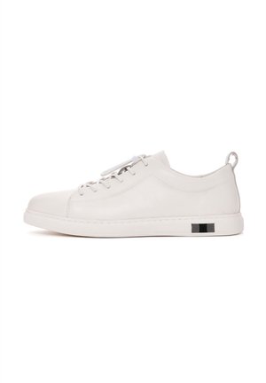 Sneaker in pelle bianca con profilo basso, design con lacci, accenti elastici e un dettaglio rettangolare nero sul tallone. Texture liscia.