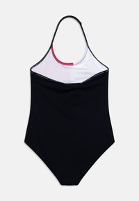 Svart baddräkt i ett stycke med hög halsringning, vit överdel och röda detaljer. Tillverkad av smidig material med en figurnära silhuett.