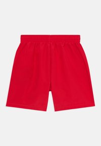 Röda idrottsshorts gjorda av lättviktsmaterial, med resårmidja och en enkel, oanpassad design utan fickor.