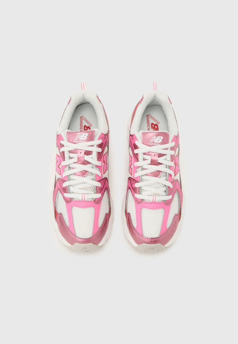 Paire de chaussures de running New Balance blanches et roses avec lacets blancs, tissu en maille et superpositions synthétiques, vues de dessus sur fond gris.