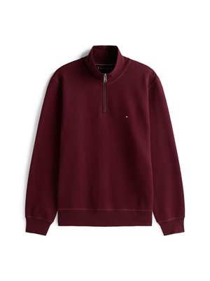 Burgundi pikad varrukad ja neljandiku tõmblukuga pullover, mille vasakul rinnal on väike Tommy Hilfiger logo, soonikkoes mansetid ja äär.