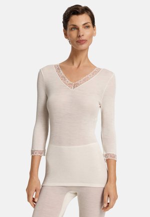 V-Ausschnitt Langarmshirt in Creme mit floraler Spitzenborte am Kragen und an den Ärmelenden, aus einem eng anliegenden, strukturierten Stoff.