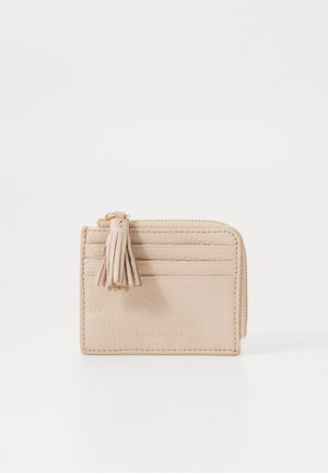 Portafoglio in pelle beige chiaro con finitura testurizzata, chiusura con zip, dettaglio a nappina e più scomparti per carte su un lato.