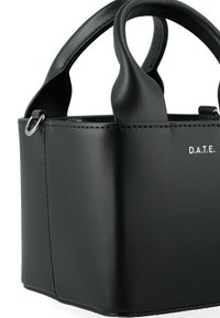 Sac à main en cuir structuré noir avec deux poignées et un détail en métal en forme d'anneau, présentant le logo blanc "D.A.T.E." sur le côté avant.