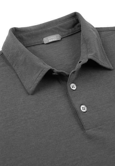 Szary polo z bawełny, z klasycznym kołnierzykiem, trzema guzikami i gładką fakturą. Widoczna subtelna metka z logo.