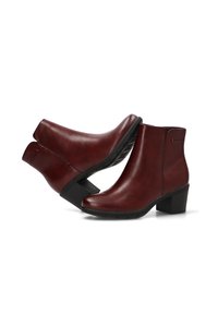 Botines de piel burdeos con puntera redondeada, tacón bloque moderado y detalles de costura sutiles; acabado suave con ligero brillo.