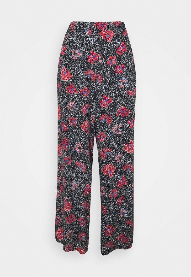 Pantalons larges noirs avec un imprimé floral rouge et violet sur fond blanc à pois, placés devant un fond clair uni.