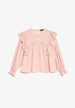 Vaaleanpunainen pusero, jossa on pitkät hihat, röyhelökoristeet, pitsiyksityiskohtia ja takana avonainen avainreikäleikkaus. Valmistettu kevyestä kankaasta, löysällä istuvuudella.