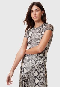 Top a maniche corte con motivo effetto serpente, caratterizzato da tonalità di grigio e beige. Tessuto leggero e testurizzato con design aderente.