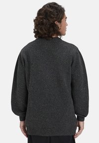Dunkelgrauer Pullover mit strukturiertem Finish und metallischen Einsprengseln, übergroßen Ärmeln sowie einem gerippten Saum und Bündchen.