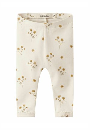 Leggings din bumbac crem cu un model floral dispersat în tonuri aurii mate, cu un tiv moale și detalii cusute pe margine.