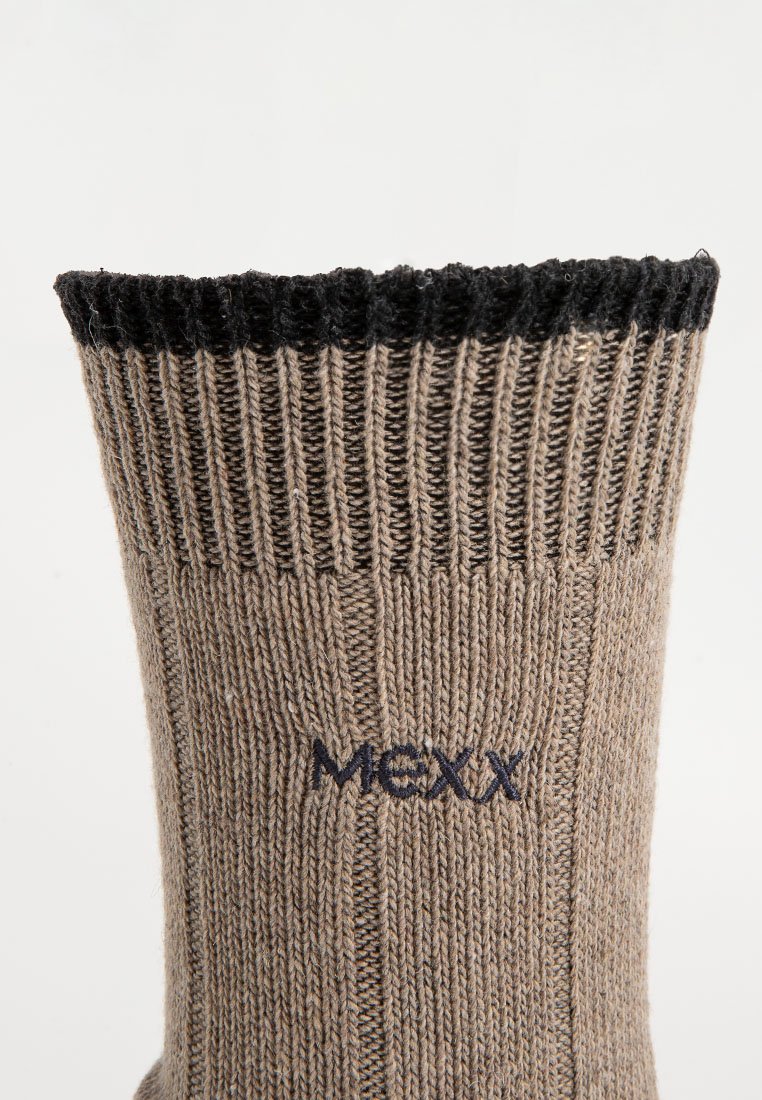 Beige gestrickte Socke mit schwarzem geripptem Bündchen und dunkelblauem, unter dem Bündchen gesticktem "MEXX"-Logo.