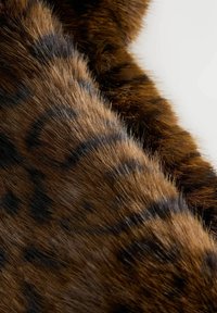 Sintetično krzno v bogati rjavi barvi z temnimi pikami, podobnimi leopardjim, z mehkimi in puhaste teksturo.
